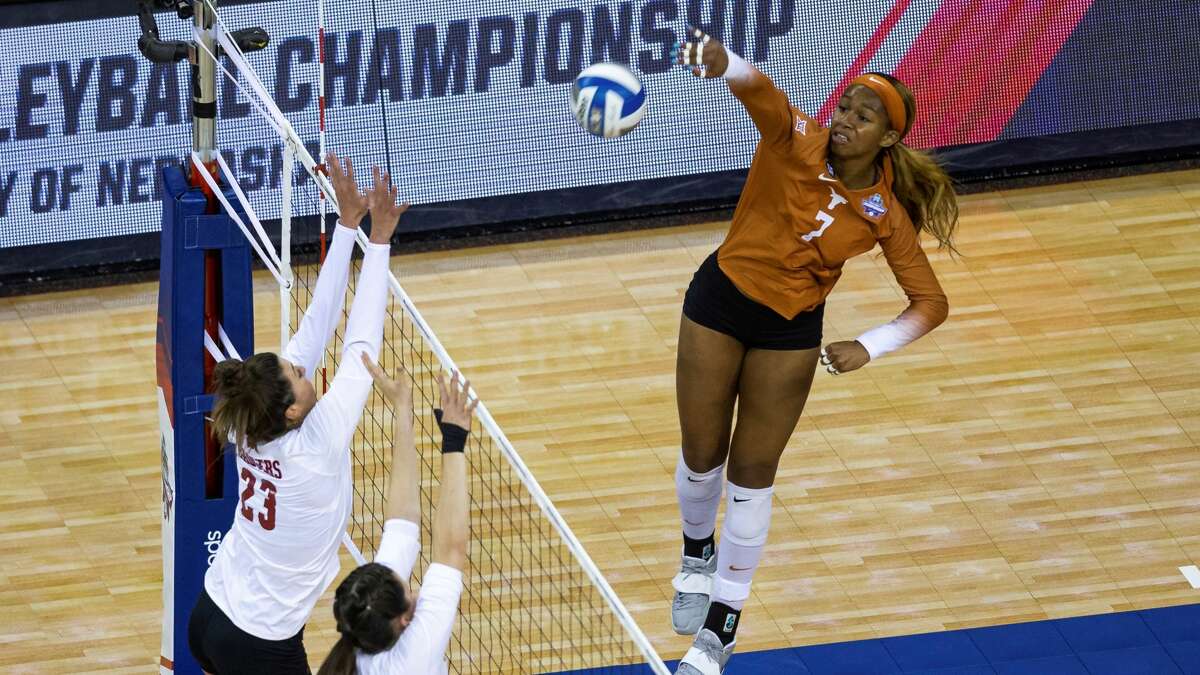 Texas' Asjia O'Neal (7) scores a point against Wisconsin's Molly Haggerty (23) and Danielle Hart (18) in the first set during a semifinal in the NCAA women's volleyball championships Thursday, April 22, 2021, in Omaha, Neb. (AP Photo/John Peterson)