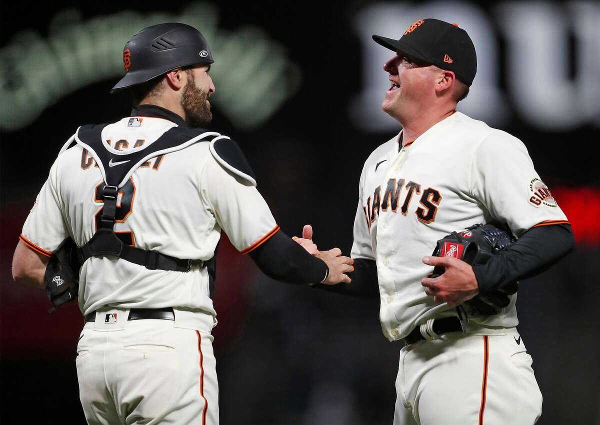 San Francisco Giants' reliever Jake McGee and catcher Curt Casali react after Giants' 3-0 win over Miami Marlins in MLB game at Oracle Park in San Francisco, Calif., on Thursday, April 22, 2021.