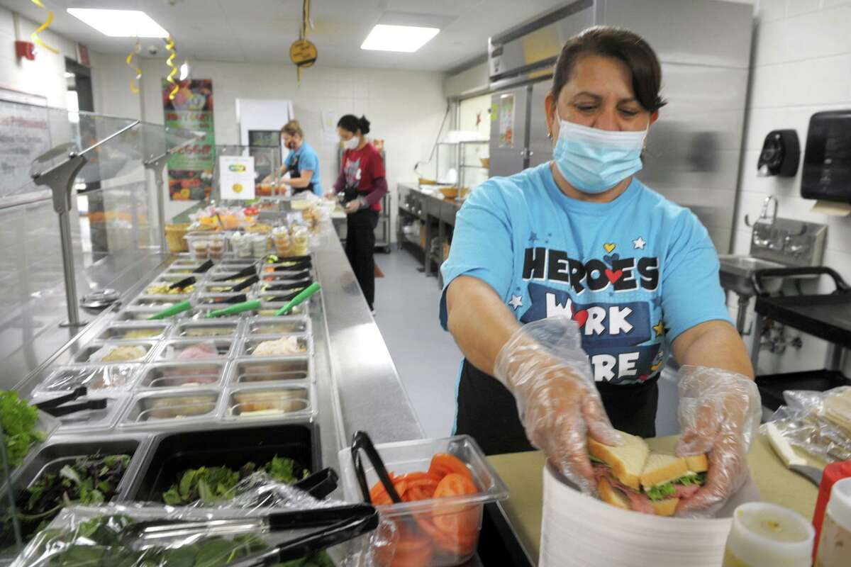 Angelica Buehler prepares made to order sandwiches for students in the cafeteria kitchen at Trumbull High School, in Trumbull, Conn. April 22, 2021.