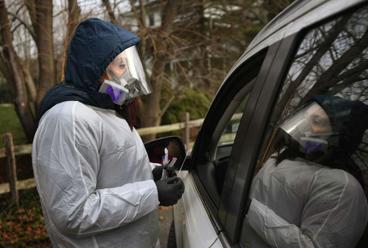 Megan Adams, of Branford, administers Covid-19 swab tests during the opening day of Griffin Hospital's drive through testing site at Unity Park in Trumbull, Conn.