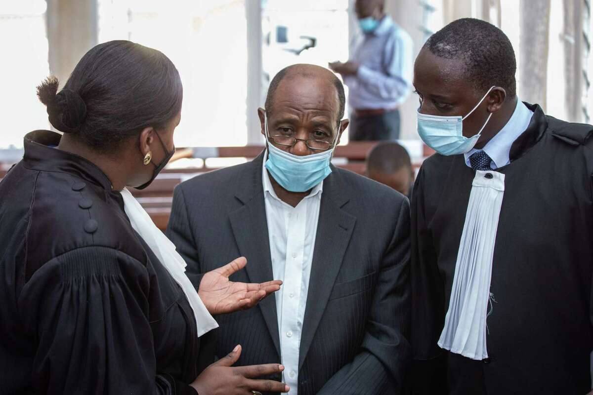 "Hotel Rwanda" hero Paul Rusesabagina (center) speaks with his lawyers at the Kicukiro Primary Court in Kigali, Rwanda, last September, when he was denied bail on terrorism charges.