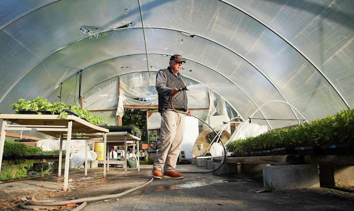Van Weldon, owner of Wood Duck Farm, waters future transplants in his greenhouse in Cleveland on Wednesday, April 21, 2021.