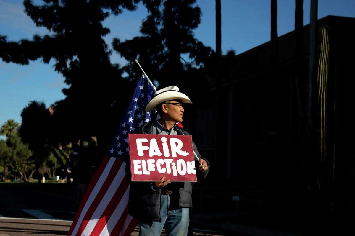 A protester stands outside the State Capitol Executive Tower in Phoenix on Dec. 14, the same day that Arizona's presidential electors met to cast their ballots.