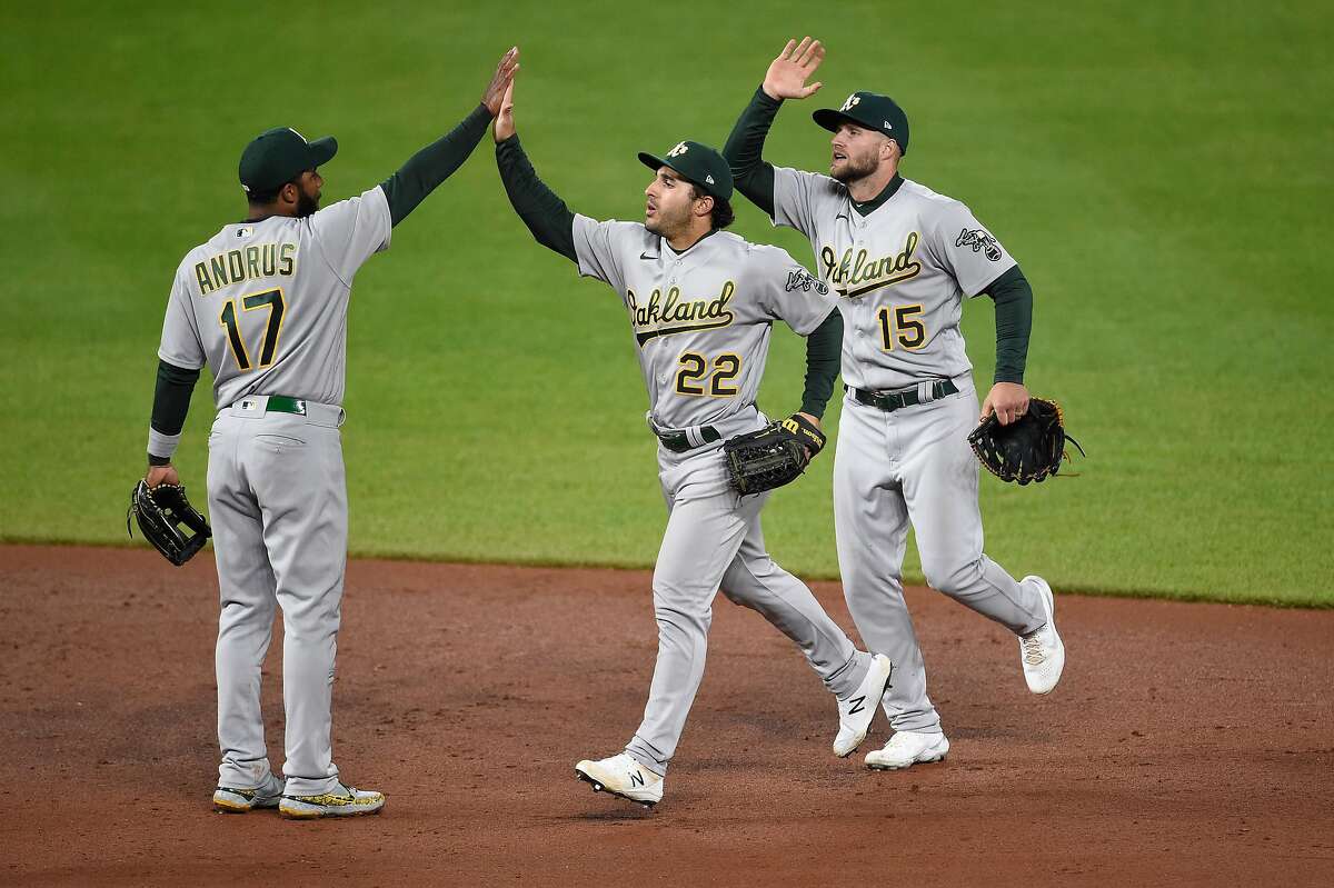 A’s shortstop Elvis Andrus (17) celebrates with Ramón Laureano (22) and Seth Brown after their win in Baltimore.