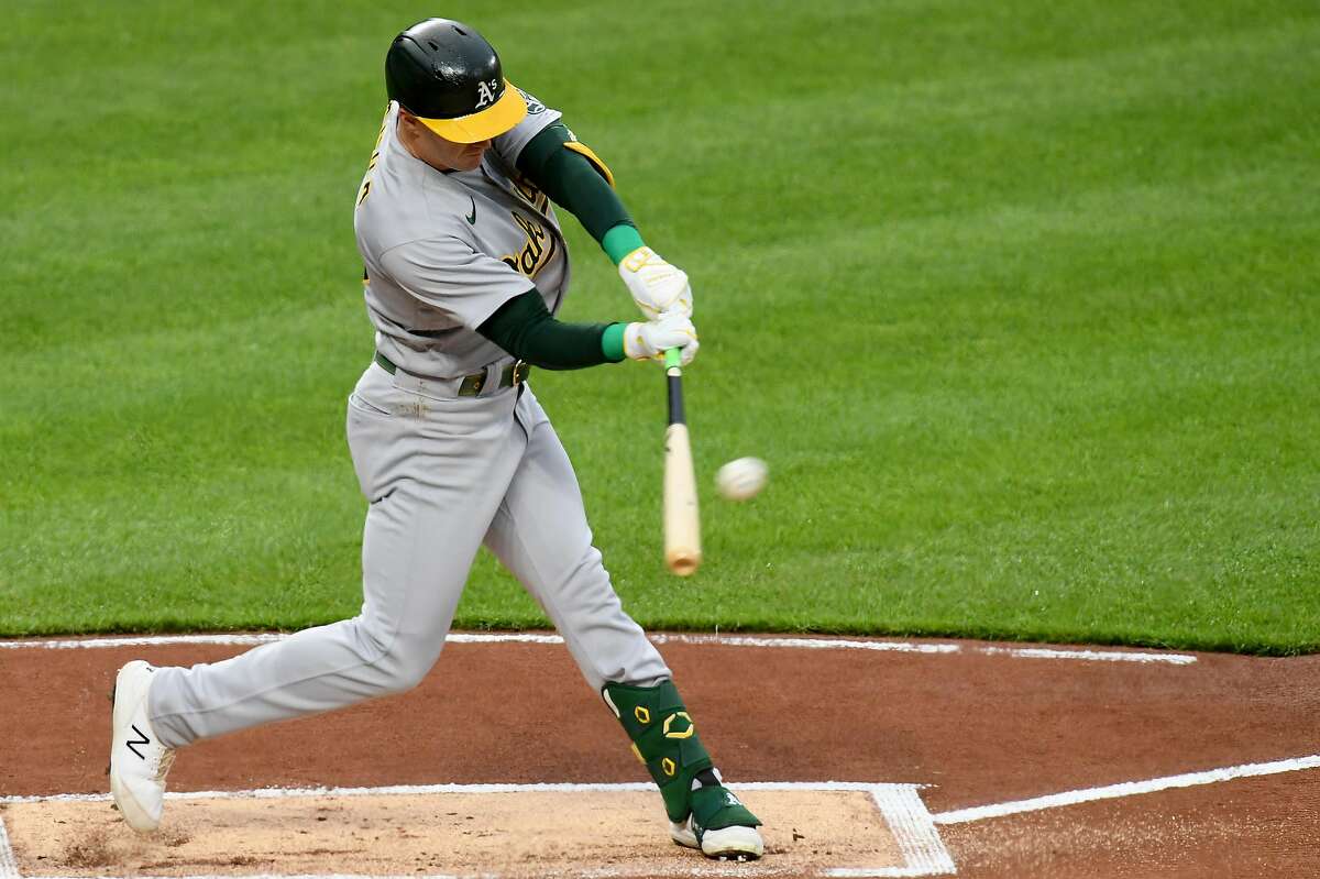 BALTIMORE, MARYLAND - APRIL 24: Mark Canha #20 of the Oakland Athletics hits a double against the Baltimore Orioles during the first inning at Oriole Park at Camden Yards on April 24, 2021 in Baltimore, Maryland. (Photo by Will Newton/Getty Images)