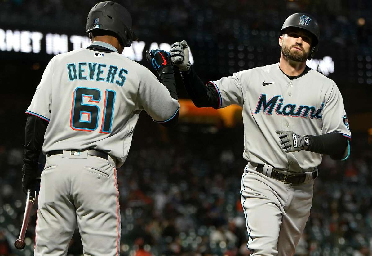 Miami’s Jose Devers (61) congratulates Jon Berti after his solo home run tied the game in the seventh inning.