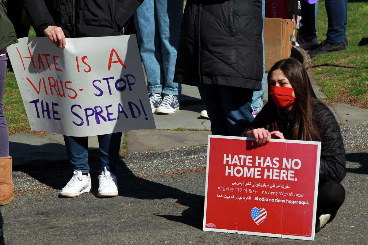 Ava Barahona, 12, sitting at right, attends a Stop Asian Hate rally on Old Town Hall Green in Fairfield, Conn., on Saturday April 3, 2021.