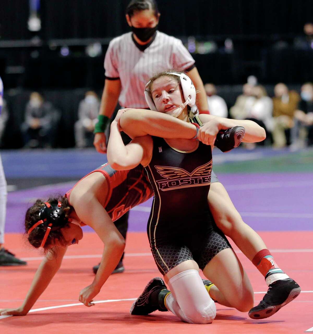 Emily Trevino with Mission Sharyland Pioneer, left, is taken down by Madison Canales with Richmond Foster, right, in the 119 weight class of the UIL Girls 5A State Wrestling Championships Friday, Apr. 23, 2021 at the Berry Center in Cypress, TX.