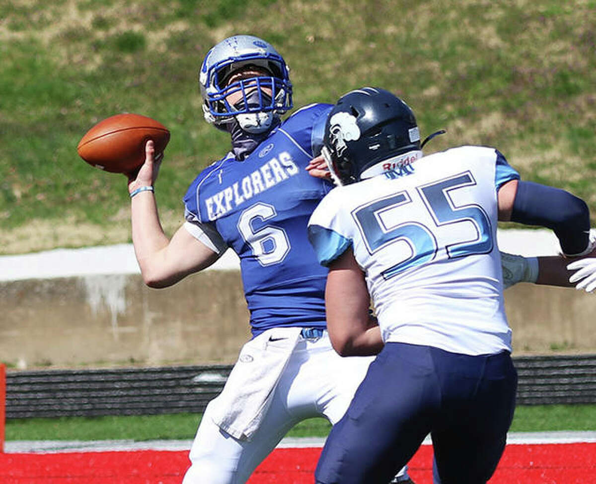 Marquette Catholic QB Jake Hewitt (6) throws a deep pass under pressure from Breese Mater Dei’s Reed Timmermann (55) in the season opener March 20 in Alton. The Explorers were back home at Public School Stadium on Saturday and Hewitt threw two TD passes in a season-ending loss to Columbia.