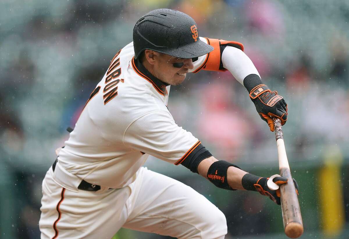 Mauricio Dubon #1 of the San Francisco Giants bunts for an rbi single scoring Wilmer Flores #41 against the Miami Marlins in the second inning at Oracle Park on April 25, 2021 in San Francisco, California.