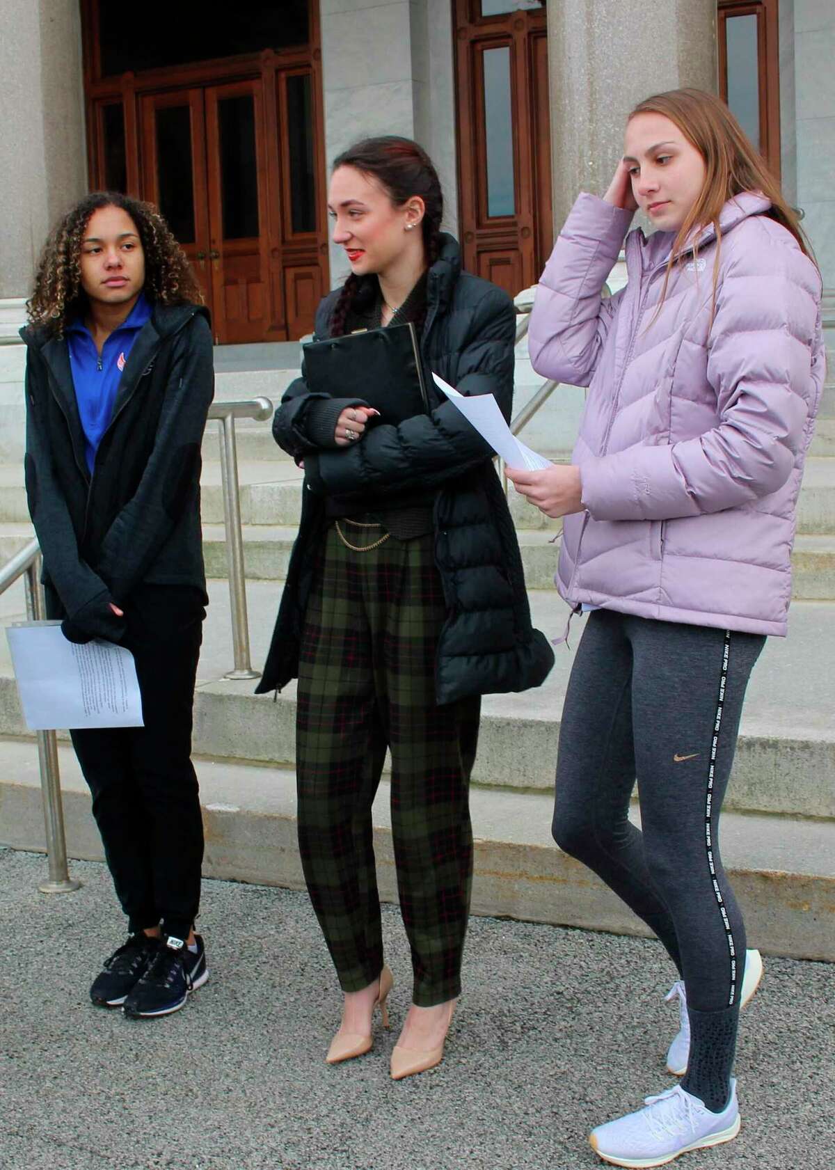 FILE - In this Feb. 12, 2020 file photo, high school track athletes Alanna Smith, left, Selina Soule, center and and Chelsea Mitchell prepare to speak at a news conference outside the Connecticut State Capitol in Hartford, Conn. The three girls have filed a federal lawsuit to block a state policy that allows transgender athletes to compete in girls sports. In a response to their lawsuit, the Connecticut Interscholastic Athletic Conference argued in a court filing that it is not subject to the federal law that guarantees equal access to women and girls in education, including athletics. (AP Photo/Pat Eaton-Robb, File)