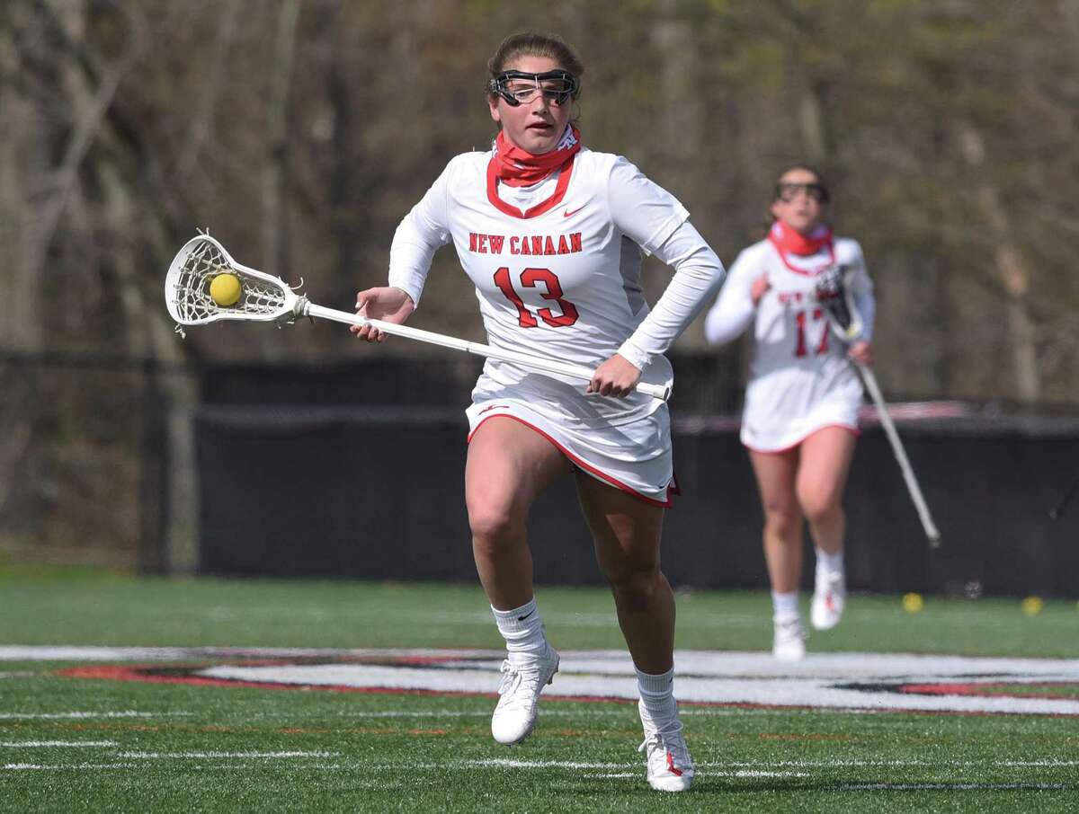New Canaan's McKenna Harden (13) races through the midfield against Darien during a girls lacrosse game at Dunning Field on Thursday, April 22, 2021.