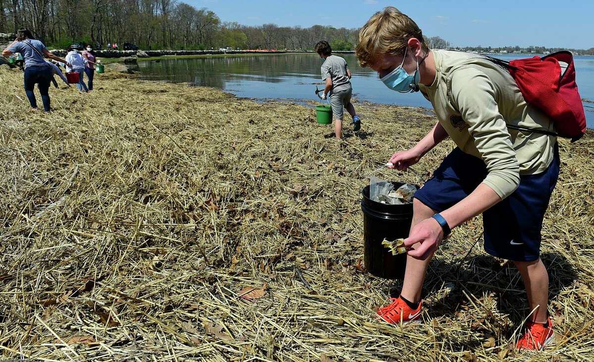 Greenwich residents join Greenwich High School students including Davies Peck as they lead a beach cleanup at Greenwich Point Park on Saturday in Greenwich. The Earth Day event, "Live Like Luke" is in memory of a GHS student, Luke Meyers, who died of cancer in 2019.