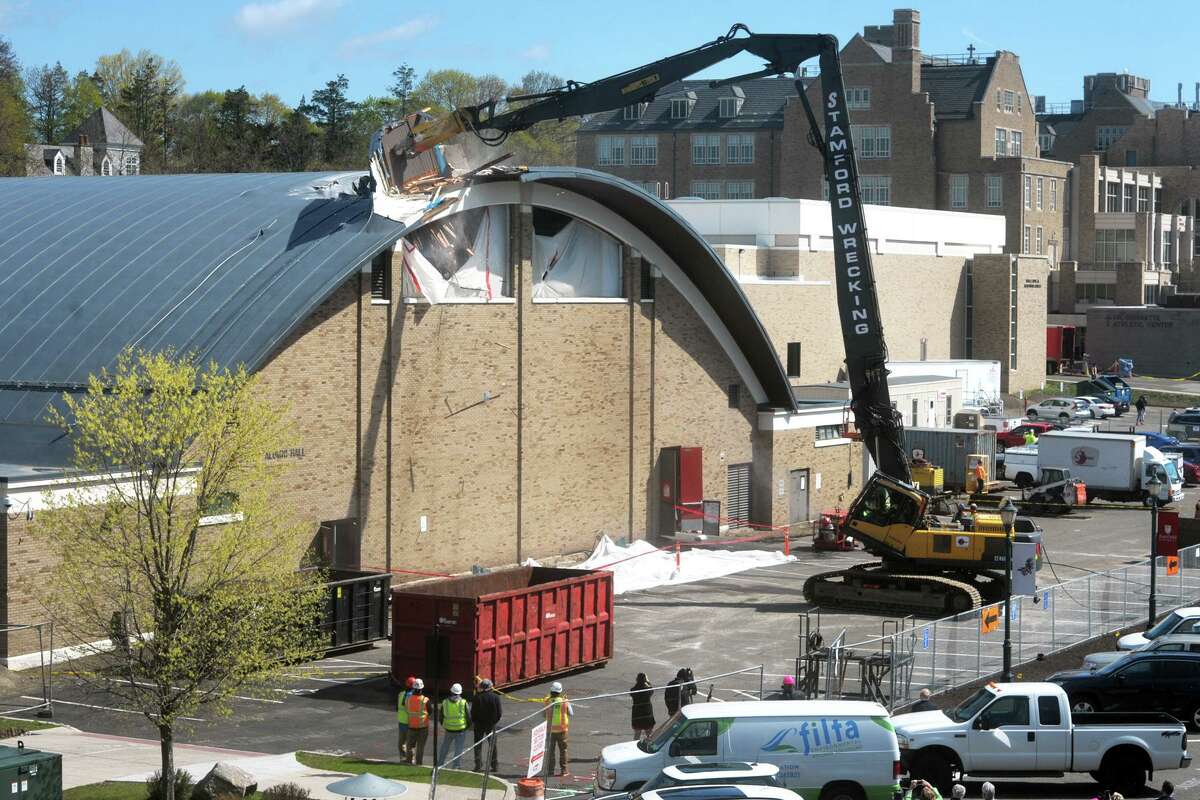 A crane begins the demolition of Alumni Hall, on the campus of Fairfield University, in Fairfield, Conn. April 26, 2021.