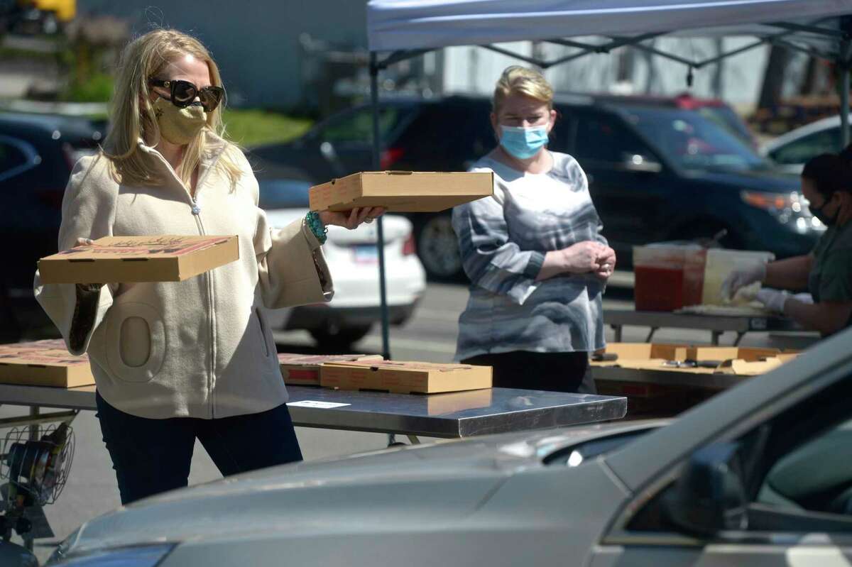 Suzanne Brennan, Executive Director of Lounsbury House, waits to deliver pizzas during the venue’s drive-thru senior lunch in Ridgefield, Conn, on Monday, April 26, 2021.