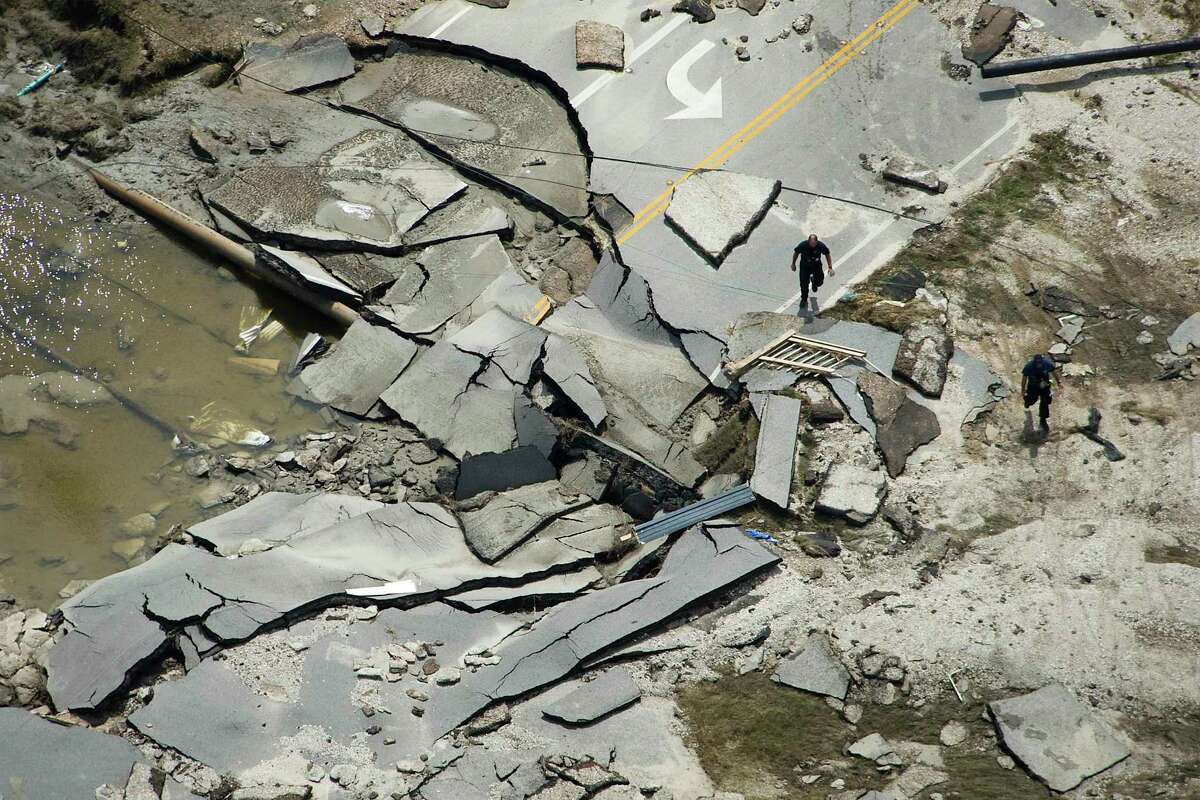 Workers walk through rubble that was left of Texas 87 on the Bolivar Penninsula after Hurricane Ike, Monday, Sept. 15, 2008.