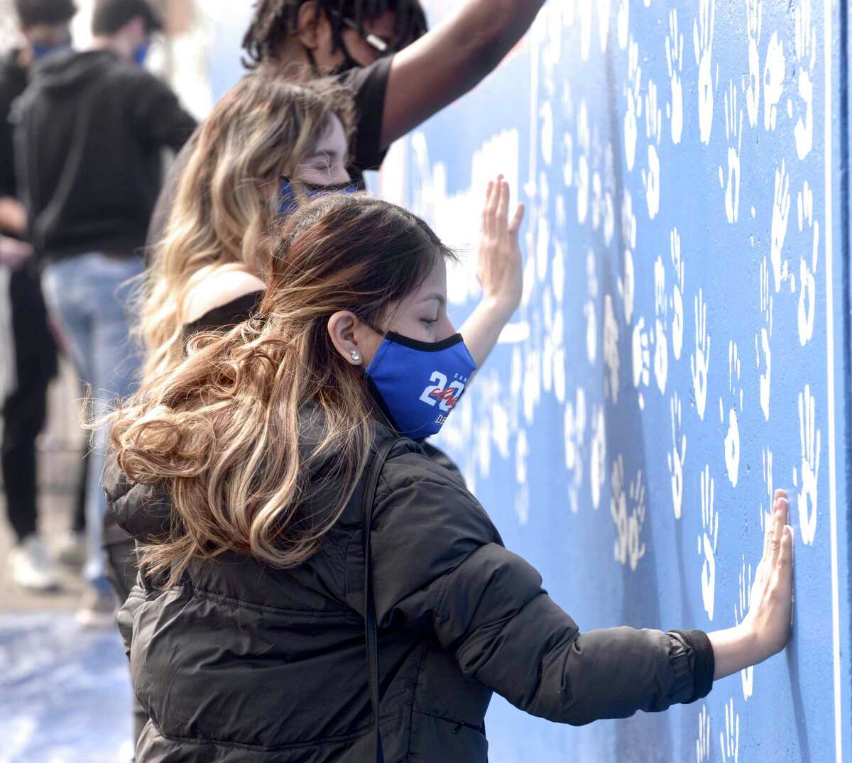 Danbury High School Senior Marlie Penaranda leaves her hand print on a mural honoring the Class of 2021. DHS seniors covered the mural with hand prints on Tuesday morning, April, 27, 2021, in Danbury, Conn.