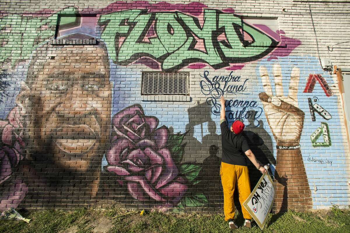 "It's a joyous day," Daryel Simmons said as she learned the verdict in the murder trial of former Minneapolis Officer Derek Chauvin in the death of George Floyd on April 20. Simmons reaches up to touch the names of Sandra Bland and Breonna Taylor as she visits a George Floyd mural near the intersection of Ennis and Elgin.