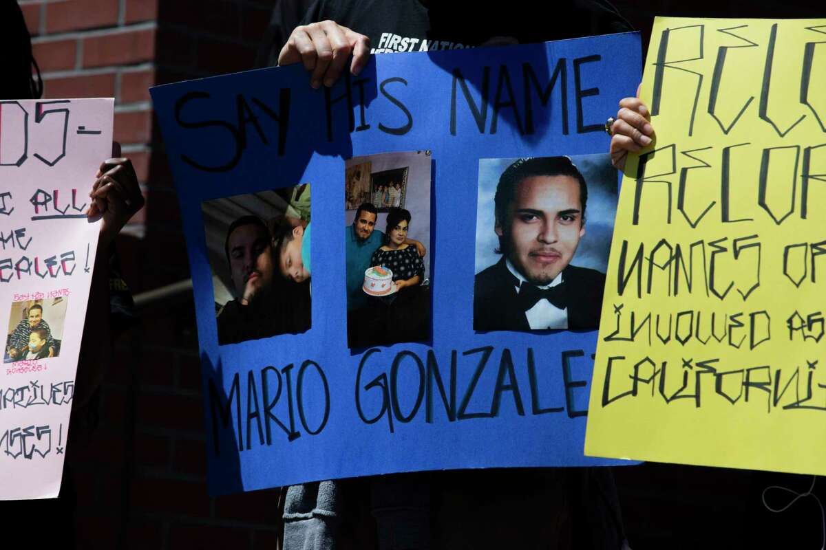 Friends, family and supporters of Mario Gonzalez holds photos of him during a news conference outside the Alameda Police Department on Tuesday, April 27, 2021, in Alameda, Calif. On Wednesday, lawyers representing Gonzalez’s family released the findings of a second, independent autopsy, which indicated that Gonzalez died of “restraint asphyxiation” after the arrest.