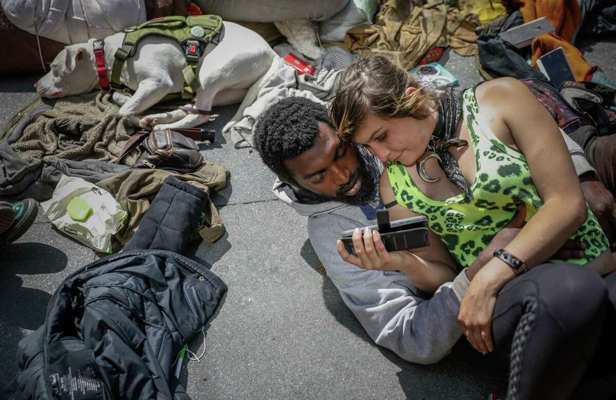 Chelsea Costello, 22, watches a video with her 26-year-old boyfriend, “Sharkbait.” They are homeless and living in the Haight.