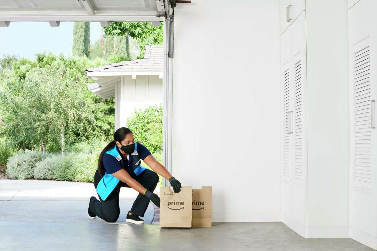 An Amazon delivery person places a grocery order inside a customer's garage. The e-commerce giant has expanded its Key by Amazon In-Garage Grocery Delivery service to more than 5,000 communities nationwide, include select Connecticut sip codes in the Hartford and New Haven areas.