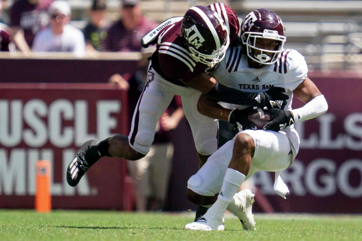 Wide receiver Moose Muhammad III, right, catches a pass against defensive back Antonio Johnson during Texas A&M’s Maroon and White spring game in College Station on Saturday.