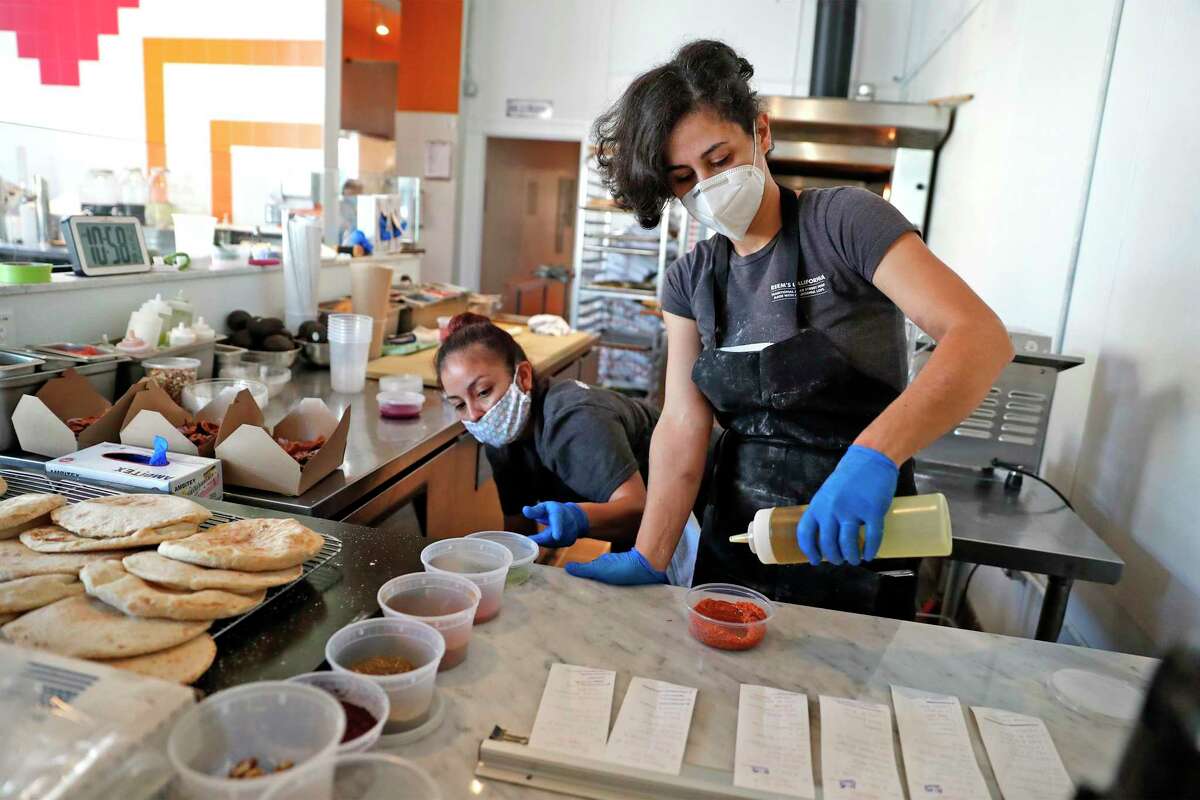 Reem Assil and Wendy Giron prepare food at Reem's in San Francisco on May 6, 2020. The restaurant is nearing the end of a conversion to worker ownership.