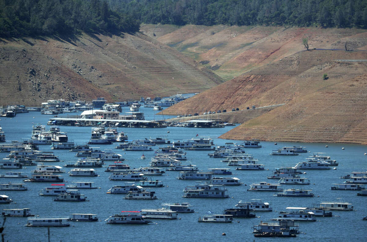 In an aerial view, houseboats are dwarfed by the steep banks of Lake Oroville on April 27, 2021 in Oroville, California. Four years after then California Gov. Jerry Brown signed an executive order to lift the California's drought emergency, the state has re-entered a drought emergency with water levels dropping in the state's reservoirs. Water levels at Lake Oroville have dropped to 42 percent of its 3,537,577 acre foot capacity.