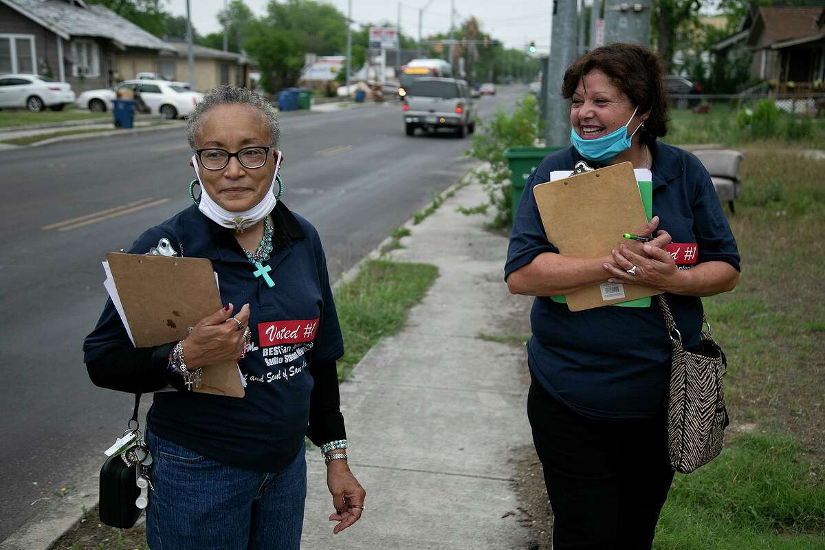 WestCare Foundation receptionist Rita Bethany, left, and community organizer Rosie Baca block walk to pass out information about what WestCare offers for local residents on April 27, 2021 in San Antonio.