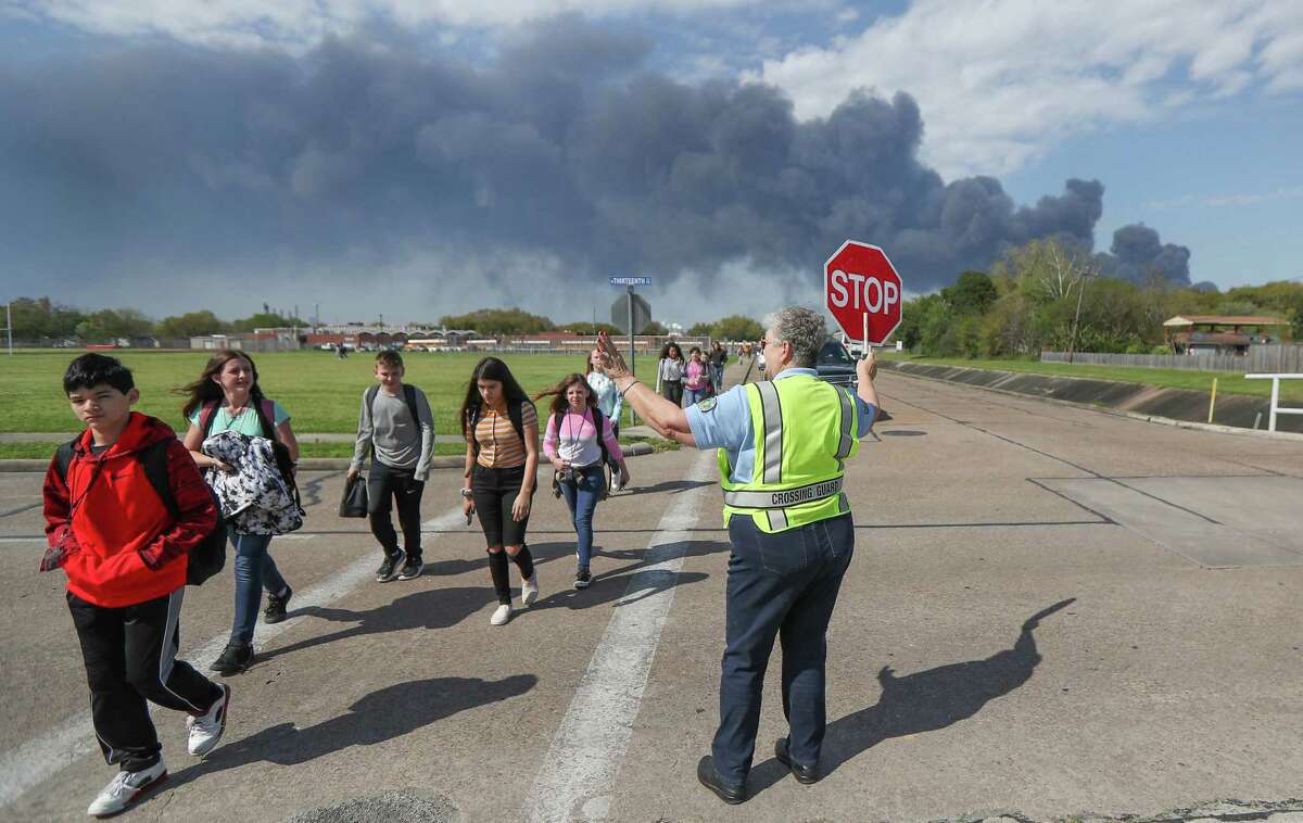 Deer Park PD Crossing Guard Adell Boren makes sure Deer Park Jr. High School students are safe as they cross East 13th and Meadowlark Streets in spite of a chemical fire burning nearby Tuesday, March 19, 2019, in Deer Park.