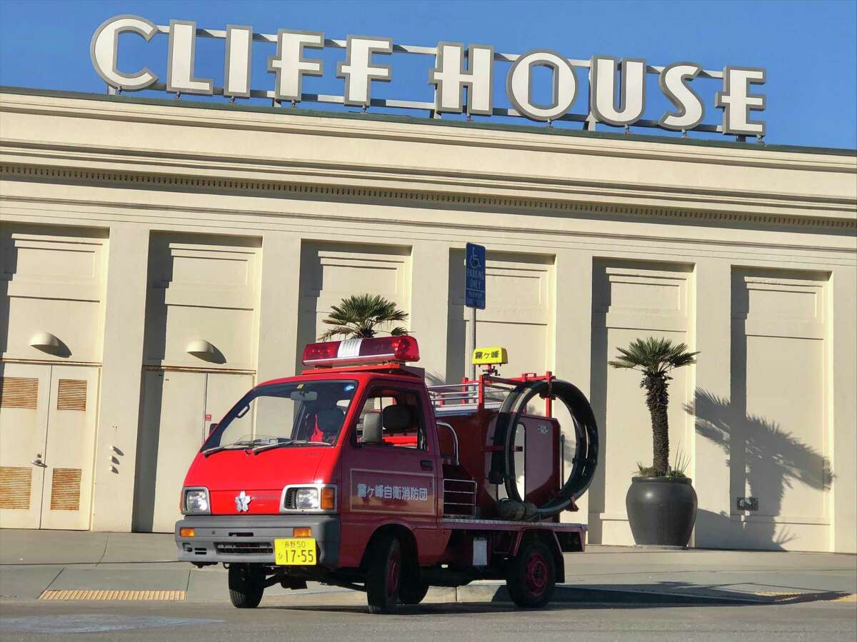 Kiri the tiny Japanese fire truck stops in front of the Cliff House in San Francisco, before the sign was removed. Kiri was bought at auction and has been touring the San Francisco Bay Area since July 2020.