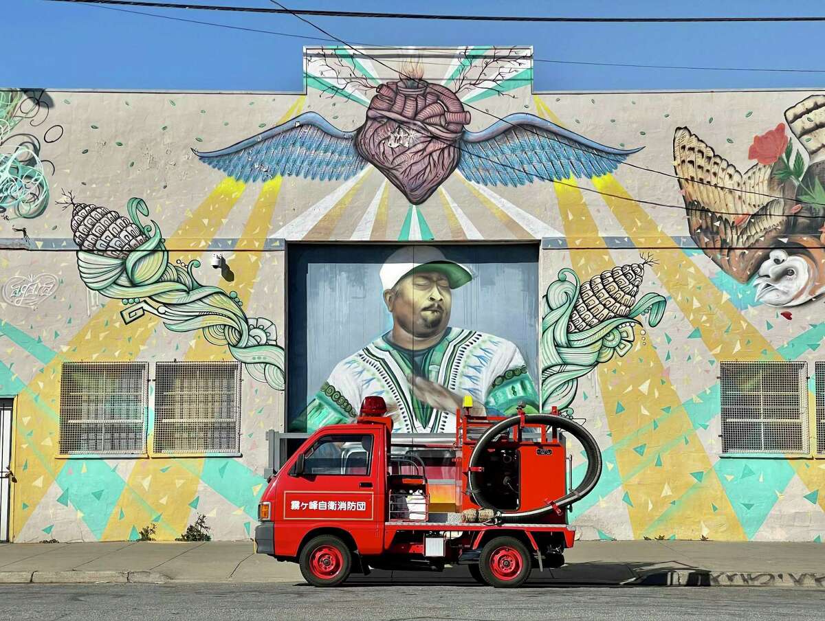 Kiri the tiny Japanese fire truck stops in front of a mural in San Francisco. Kiri was bought at auction and has been touring the San Francisco Bay Area since July 2020.