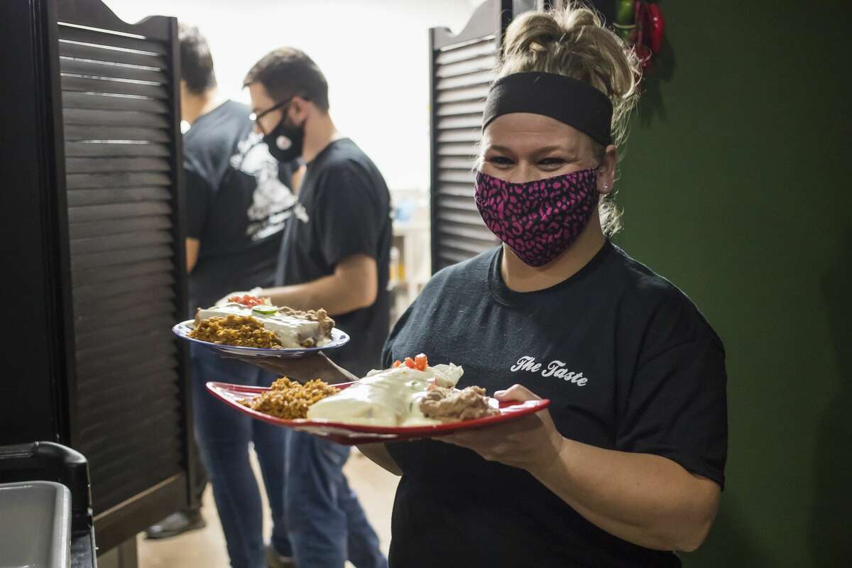 Danielle Colegrove carries plates of food to a table during opening day at The Taste of Midland, a new Tex-Mex restaurant located at 3001 S. Saginaw Road in Midland. (Katy Kildee/kkildee@mdn.net)