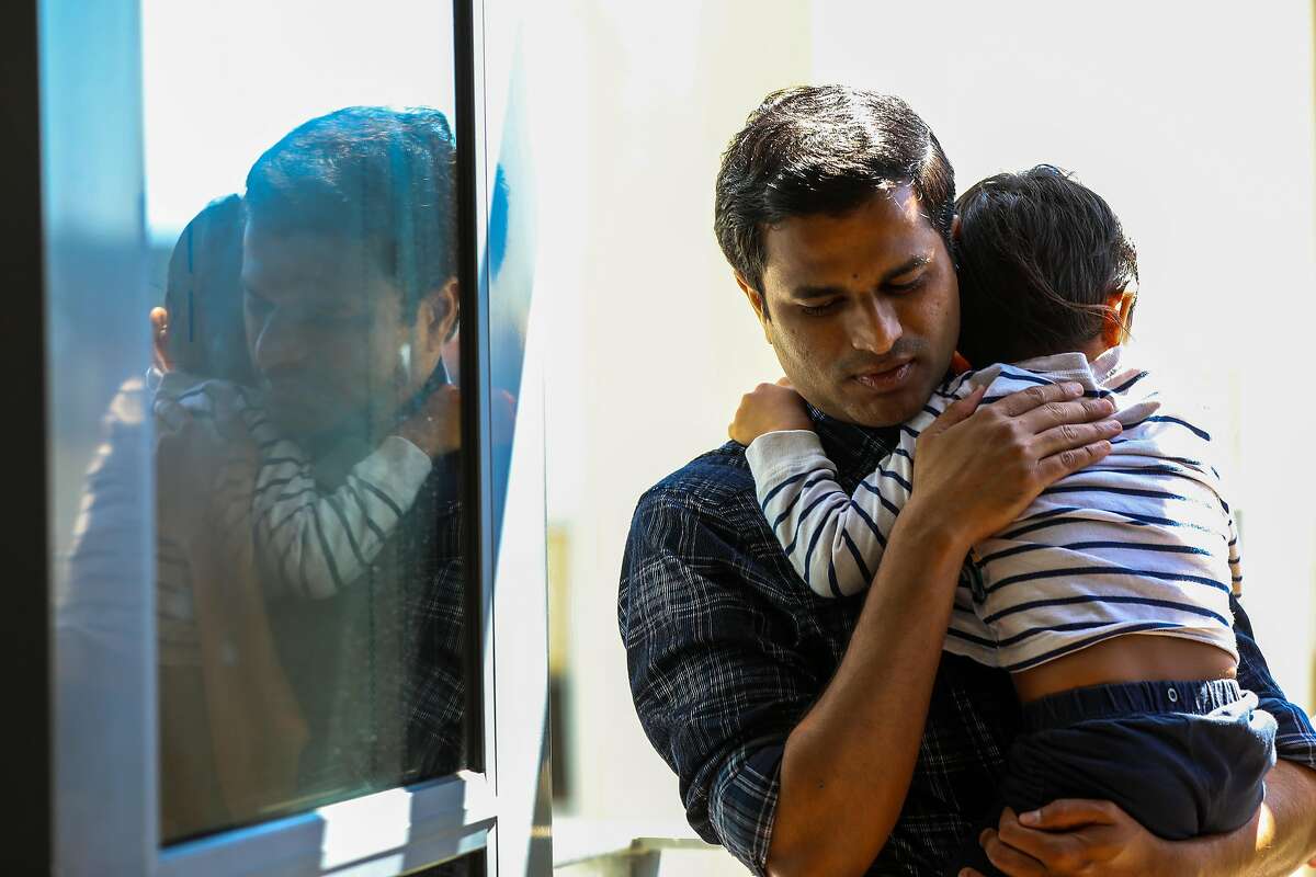 Rahul Suryawanshi, 36, holds his son Prathamesh, 3.5, at home on Wednesday, April 28, 2021, in San Francisco, Calif. Suryawanshi is a scientist at the Gladstone Institutes who studies the coronavirus in mice. His parents, grandmother, brother, cousins and 3-month-old niece all became infected with the virus, and most ended up in the hospital. Suryawanshi's 54-year-old mother is still in intensive care and he worries constantly about the oxygen supply constraints in India now.