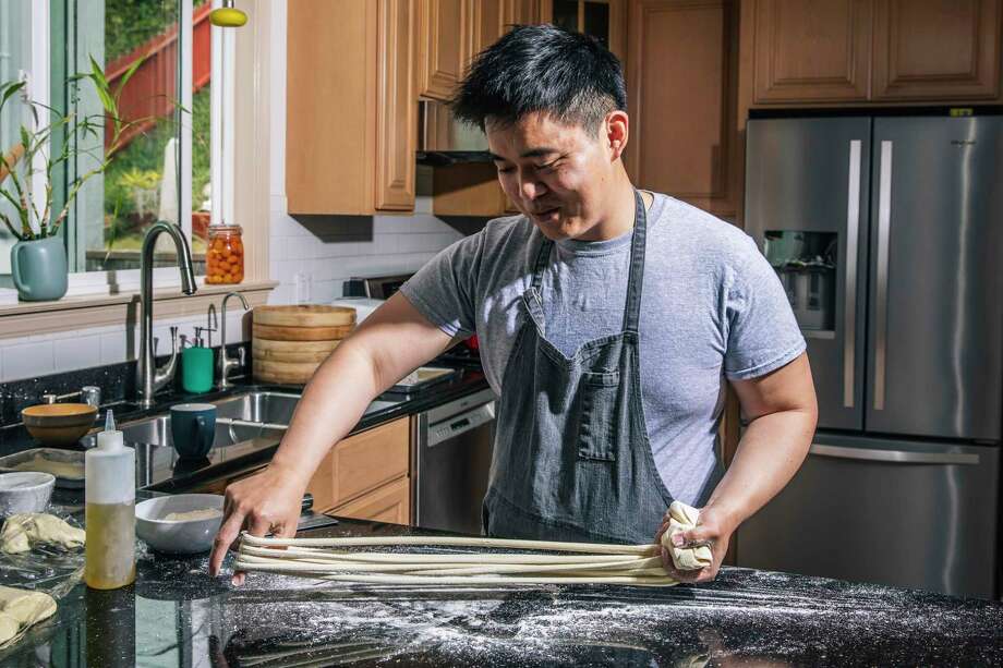 William Lim Do, founder of Lao Wai Noodles and former sous-chef at Mister Jiu’s, prepares to pull da kuan, or large-width noodle, at his home in Daly City. Photo: Stephen Lam/The Chronicle 2021 / San Francisoc Chronicle