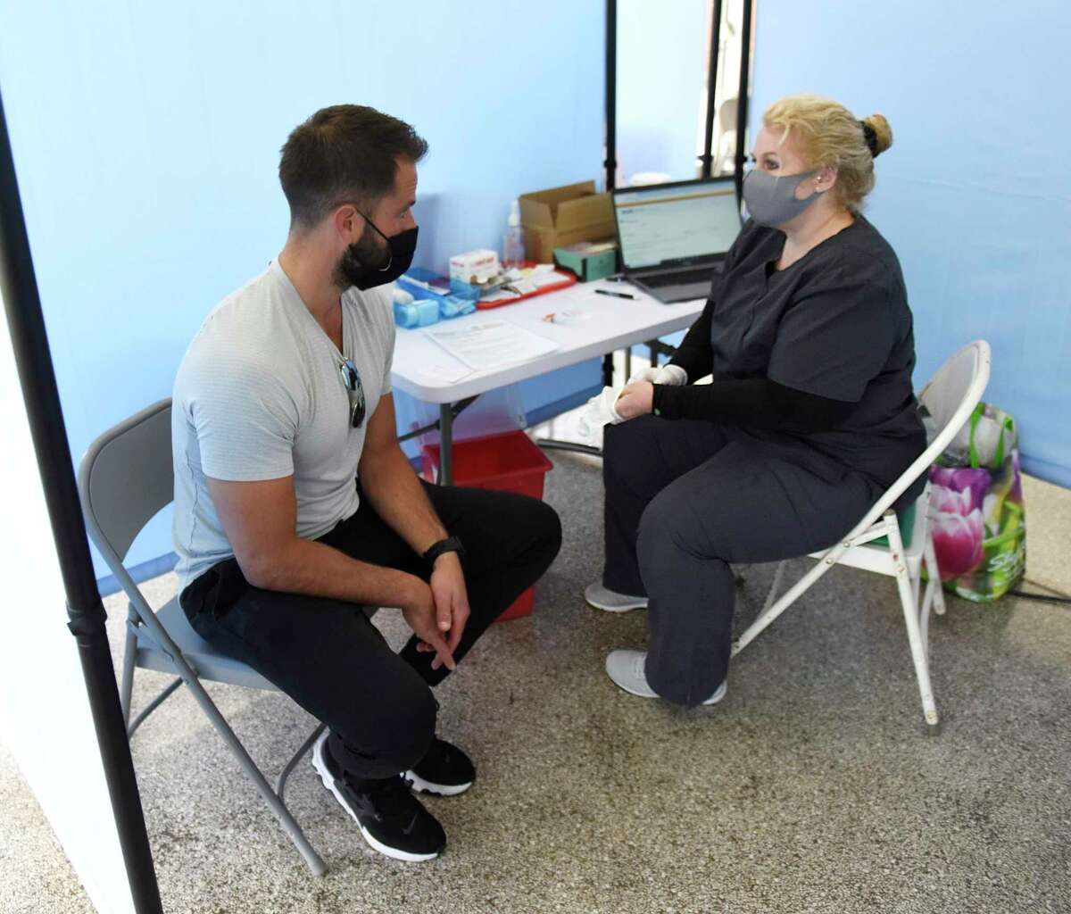 Chistine Plateroti, LPN, chats with Greenwich’s Dan Agostino before administering the COVID-19 vaccine at the Family Centers Vaccination Clinic at the Eastern Greenwich Civic Center.