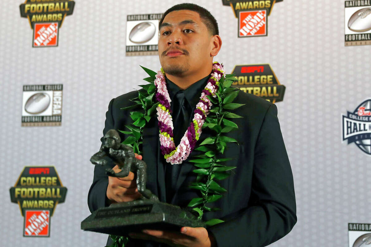 FILE - In this Dec. 12, 2019, file photo, Oregon's Penei Sewell poses with Outland Trophy for being the nation's best interior lineman, in Atlanta. Sewell is a likely first round pick in the NFL Draft, April 29-May 1, 2021, in Cleveland.(AP Photo/, File)