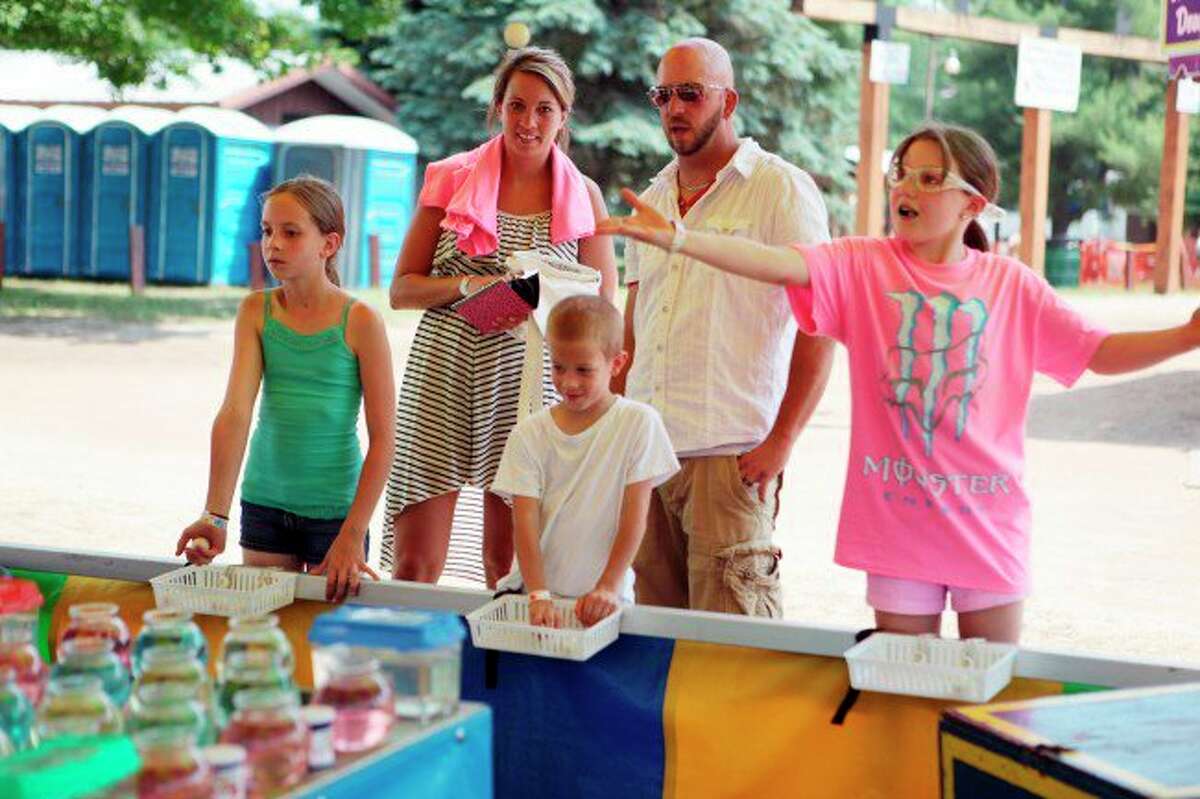 In this Star file photo, a family is pictured playing a carnival game at the Flea Roast and Ox Market Festival in Irons. Organizers have canceled this year's festival. (Star file photo)
