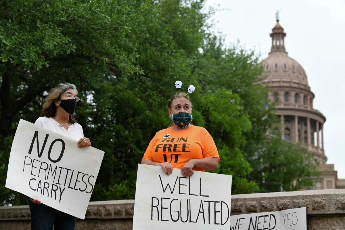 Tracy Gehman, left, and a woman who identified herself as "Lola" display their opposition to permitless gun carry as legislators take up the issue in the Texas Capitol on Thursday, April 15, 2021.