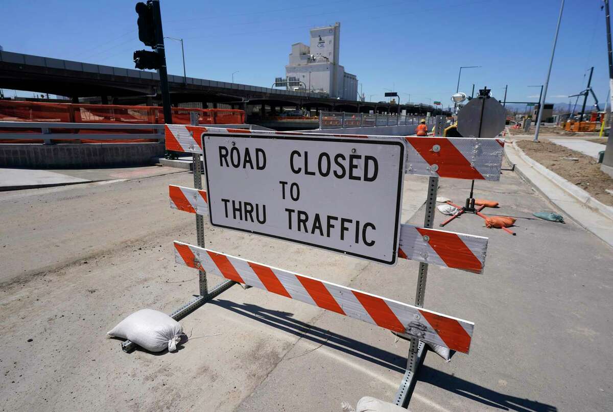 A road closed sign blocks a roadway under construction along what will become Interstate 70 north of downtown Denver.