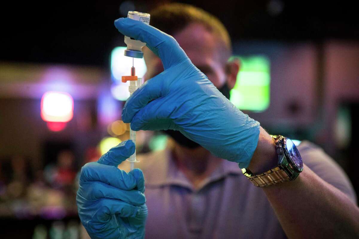 Ruston Tayor fills a syringe with a dose of Moderna COVID-19 vaccine during a pop-up vaccination clinic at BUDDY'S Houston in Montrose on Thursday, April 29, 2021 in Houston. BUDDY'S teamed up with Wellness Bar by Legacy to offer vaccines by appointment.