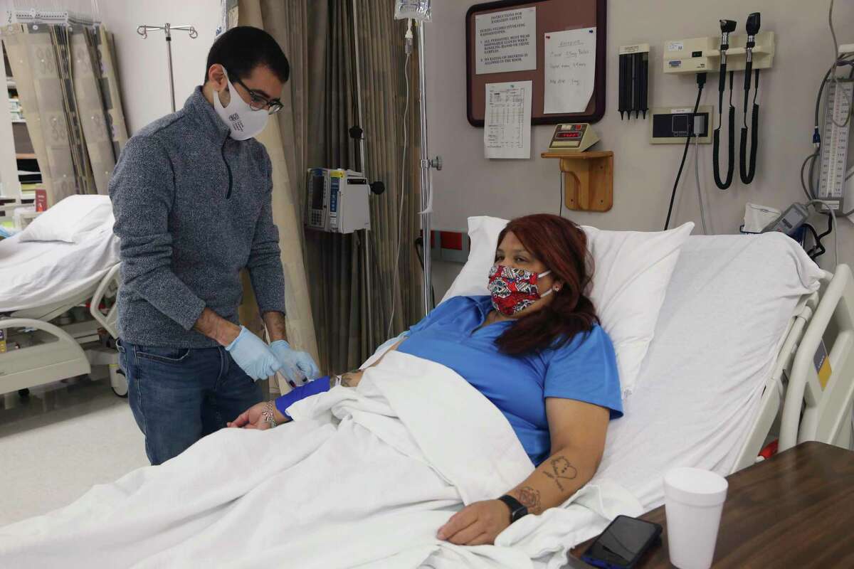 Research fellow Mohamed Eletrebi, 29, draws blood from Melissa Mata, 55, for glucose testing at the Texas Diabetes Institute on April 30, 2021. On March 31, Mata underwent an experimental procedure that removed internal fat from around her intestines. It has already helped reverse the effects of her Type 2 diabetes.