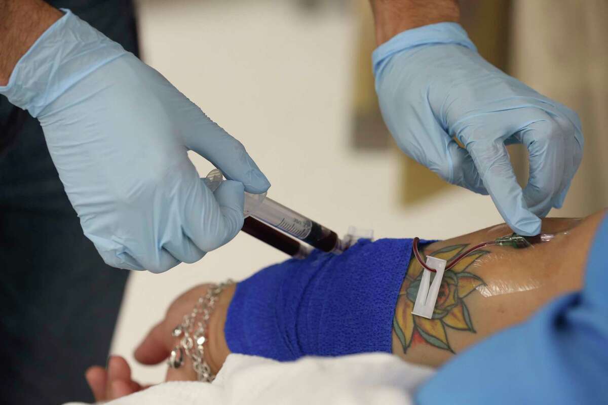 Research fellow Mohamed Eletrebi, 29, draws blood from Melissa Mata, 55, for glucose testing at the Texas Diabetes Institute on April 30, 2021. Mata was the second patient ever to undergo a procedure to remove internal abdominal fat to treat Type 2 diabetes. The treatment is being studied by researchers at UT Health San Antonio, University Health and Texas Biomedical Research Institute.