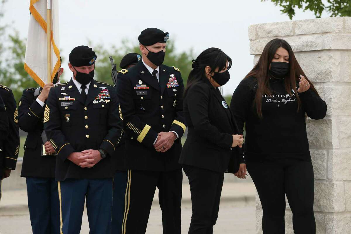 Lupe Guillen, second from right, and her sister, Mayra, stand by a sign at an entrance to Fort Hood renamed in honor of their sister, Spc. Vanessa Guillen, last week. On the left is Fort Hood Command Sgt. Maj. Arthur Burgoyne and Lt. Gen. Pat White.