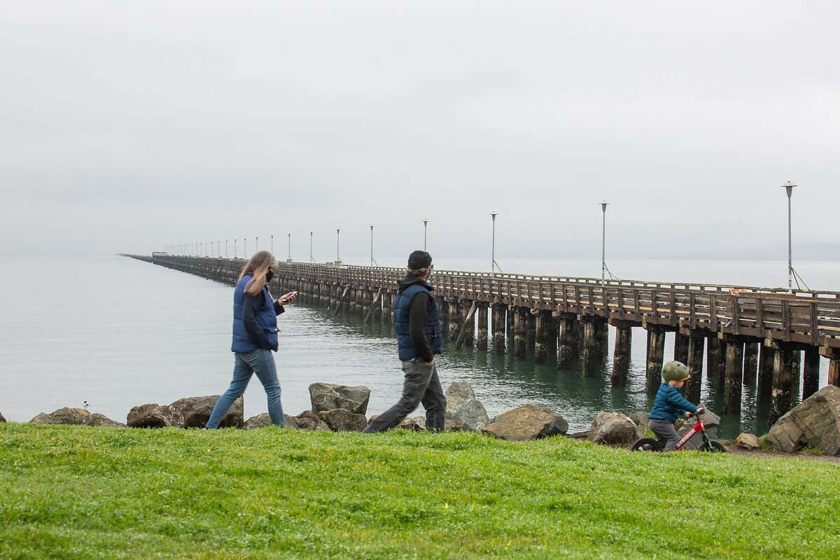 A family strolls past the closed Berkeley Pier on Feb. 19.