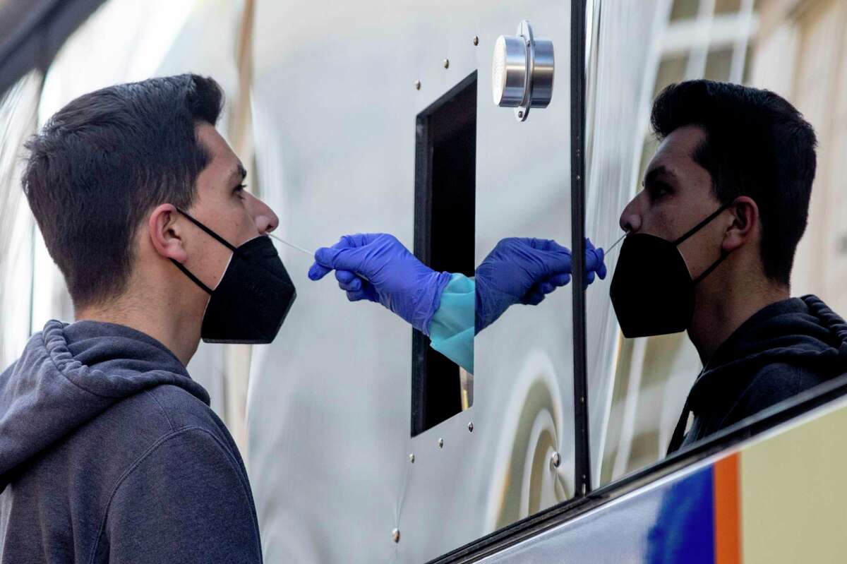 Manuel Flores gets a COVID-19 nose swab test at the BusTest Express mobile test site in Berkeley on Jan. 26, 2021.