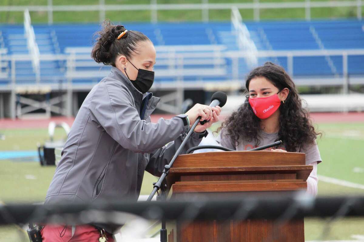 Middletown High School seniors, who have not fully gathered together since before the pandemic, celebrated college acceptance day Friday morning on the athletic field. Class president Ani Zakarian, right, gets a little help with the microphone before she addressed her classmates.