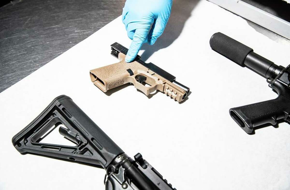 An Oakland Police Department service technician displays unregistered and untraceable firearms, known as “ghost guns.”