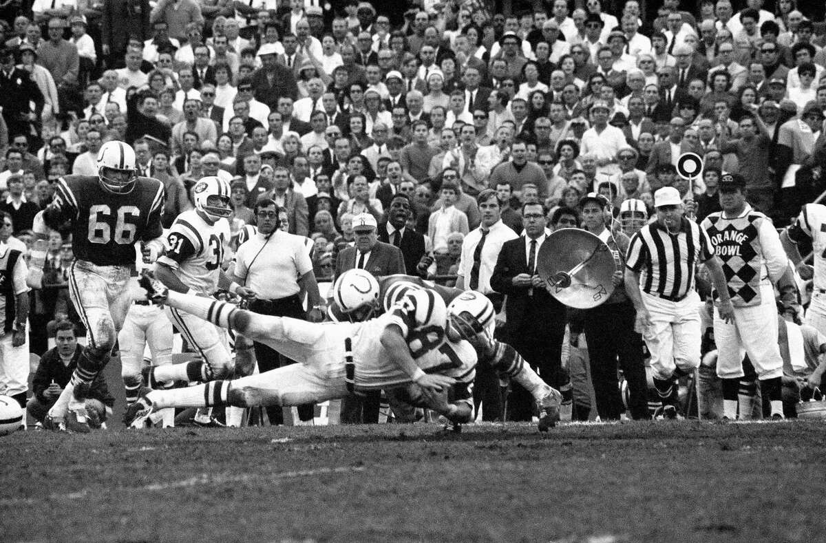 New York Jets Pete Lammons (87) dives as he is hit by a defender in Super Bowl III, Jan. 13, 1969 in Miami. Among the viewers of the actions the sideline is Jets coach Weeb Ewbank in the white cap at center. (AP Photo/Harold Valentine)