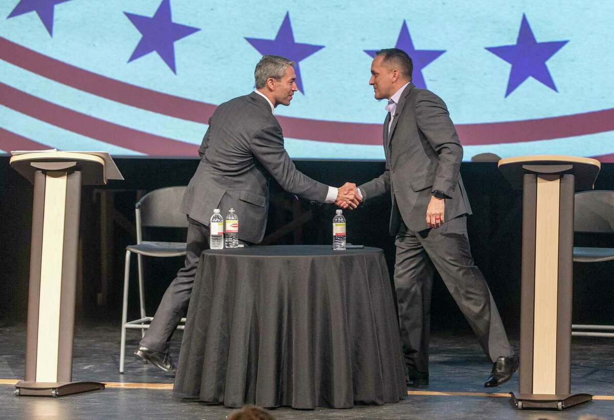 Mayor Ron Nirenberg, left, and Councilman Greg Brockhouse shake hands after participating in a 2019 forum. San Antonio’s mayoral and City Council races are nonpartisan.